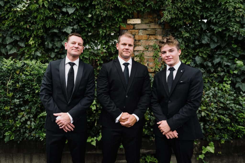 Groom and groomsmen standing outside grounds of Alexandria before wedding captured by james white photography