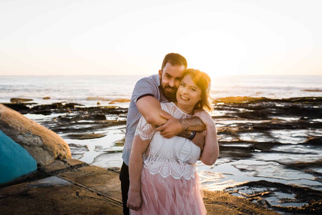 beautiful shot of bride and groom posing against the ocean and rockpool captured by james white newcastle wedding photographer