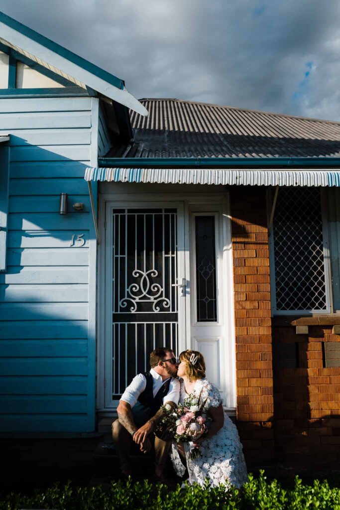 bride and groom sit on step out front of their home before they leave for wedding captured by james white newcastle wedding photographer